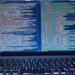 black laptop computer turned on showing computer codes